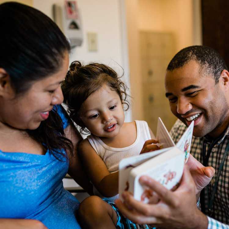 Mom and Dad Reading to their young daughter